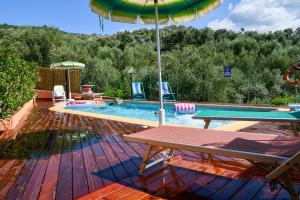 a swimming pool with a table and an umbrella at Gli Angeli Agriturismo in Cisano sul Neva