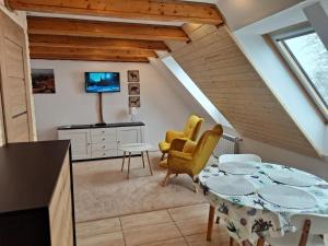 a kitchen and dining room with a table and chairs at Apartamenty Pod Lipą in Lutowiska