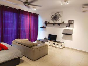 - un salon avec un canapé et une télévision dans l'établissement Trefoil, à Setia Alam