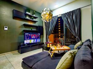uma sala de estar com um sofá e uma televisão em Petalz Luxury Suite 10Pax MID VALLEY OLD KLANG ROAD OUG KLANG LAMA KL em Kuala Lumpur