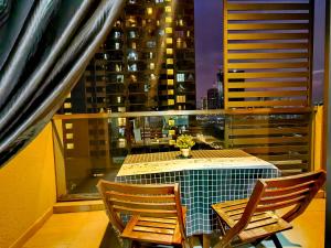 uma mesa e cadeiras numa varanda com vista para a cidade em Petalz Luxury Suite 10Pax MID VALLEY OLD KLANG ROAD OUG KLANG LAMA KL em Kuala Lumpur