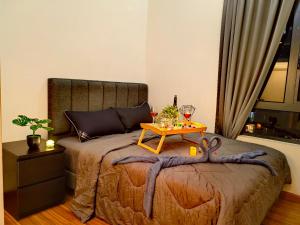 ein Bett mit einem Tisch und Weingläsern darauf in der Unterkunft Petalz Luxury Suite 10Pax MID VALLEY OLD KLANG ROAD OUG KLANG LAMA KL in Kuala Lumpur