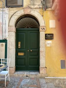 a green door in a building with an arch at Taormina B&B in Taormina