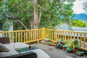 a porch with a yellow fence and some plants at Lijiang Yunqi Holiday Guesthouse in Lijiang