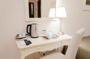 escritorio blanco con cafetera y lámpara en Taormina B&B, en Taormina