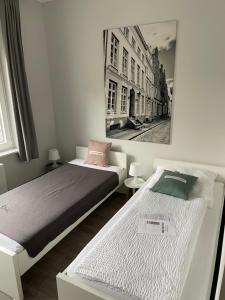 2 Betten in einem Schlafzimmer mit einem Bild an der Wand in der Unterkunft meierstrasse in Lübeck