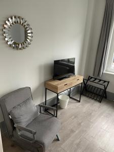 - un salon avec une chaise, un bureau et un miroir dans l'établissement meierstrasse, à Lübeck