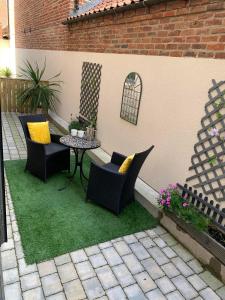 un patio con sillas y una mesa sobre hierba en York Staycation with Free Parking en York