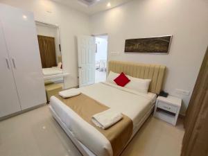 1 dormitorio con cama grande y almohada roja en Le Villagio Resort & Domes, en Sultan Bathery