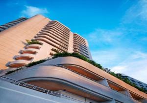 un edificio alto con plantas a su lado en S.M. GRANDE RESIDENCE, en Bangkok