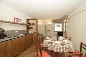 una sala da pranzo con tavolo e una cucina di Nuovo Appartamento Super Vista a Campiglio Parking Privato a Madonna di Campiglio