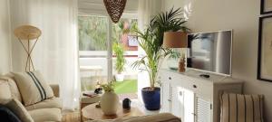 uma sala de estar com televisão e vasos de plantas em Kentia golf Playa Granada em Motril
