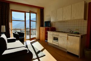 eine Küche mit Sofa und Herd Top-Backofen in der Unterkunft Sun Apartments - with Dolomiten Panorama in Lienz