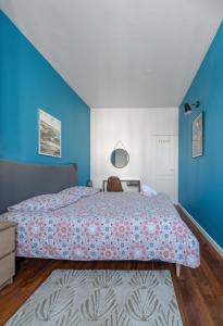 1 dormitorio con cama y pared azul en Le 482 - Grand Appartement design & Confort - 4 chambres, en Vichy