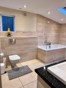 a bathroom with a tub and a toilet and a sink at Ashfield Bed & Breakfast in Belfast