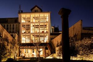 een groot wit gebouw met 's nachts verlichting bij ACOUGA Hotel Boutique in Celanova