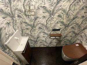 uma casa de banho com WC e papel de parede tropical em WOLF PACK apartment 1002 em Osaka