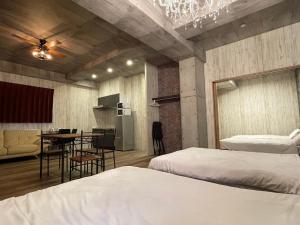 sypialnia z 2 łóżkami i stołem oraz kuchnia w obiekcie WOLF PACK apartment 1002 w Osace