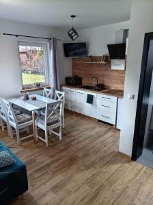 a kitchen and dining room with a table and chairs at Domek nad potokiem in Grywałd