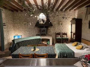 a living room with a table and a couch at Le Relais, La Dormance, Le Bois Dormant in Châteauvieux