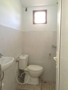 a white bathroom with a toilet and a sink at Homestay dekat Darussalam & Ulee Kareng in Lamnyong