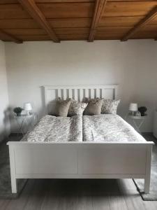 1 dormitorio blanco con 1 cama blanca grande con almohadas en Appartement mit Alpensicht, beheiztem Pool, Garten, 