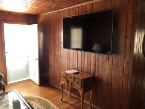 salon z telewizorem na drewnianej ścianie w obiekcie BlackBeard's Retreat - Historic and Pet Friendly cottage w mieście Kitty Hawk