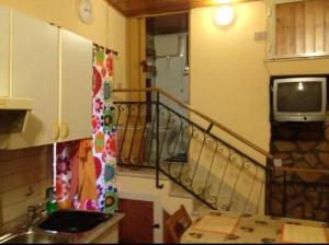 a kitchen with a staircase with a television and a sink at Cavour Apartment in Syracuse