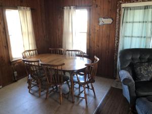 a dining room with a wooden table and chairs at BlackBeard's Retreat - Historic and Pet Friendly cottage in Kitty Hawk