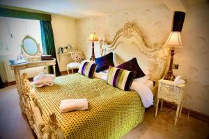 een slaapkamer met een groot geel bed met kussens bij Angmering Manor Hotel in Angmering
