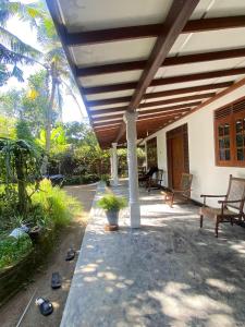 希卡杜瓦的住宿－Guruge villa，木屋顶房子的门廊