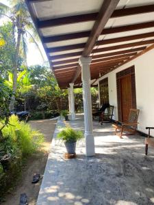 Guruge villa في هيكادوا: شرفة منزل مع سقف خشبي