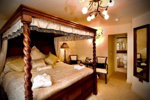 a bedroom with a canopy bed with towels on it at Angmering Manor Hotel in Angmering