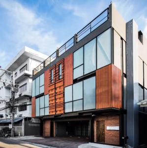 an office building with glass and timber facade at Any Day House Huahin in Hua Hin