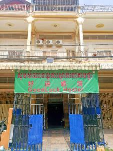 a building with a sign on the front of it at Good Luck Hostel in Phnom Penh