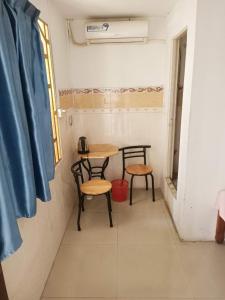 a small table and two chairs in a room at Good Luck Hostel in Phnom Penh