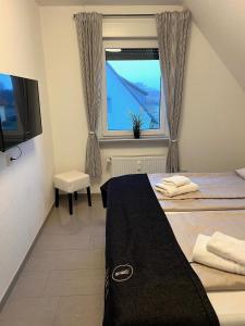 ein Hotelzimmer mit 2 Betten und einem Fenster in der Unterkunft Ferien-Whg Möwe nähe Steinhuder Meer in Hagenburg