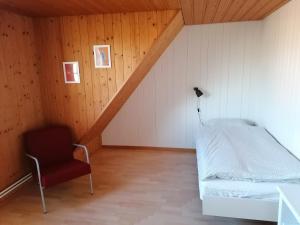 a bedroom with a bed and a chair in a room at Like on cloud nine - Apartment in Emmental 