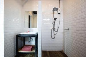 a white bathroom with a sink and a shower at Any Day House Huahin in Hua Hin