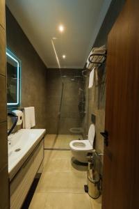 a bathroom with a toilet and a sink and a shower at The Kailyn Hotels&Suites Ataşehir in Istanbul