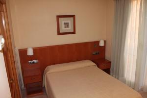 a small bedroom with a bed and a picture on the wall at Hotel del Port in L'Ametlla de Mar