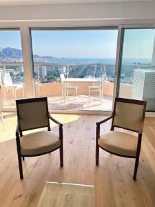 two chairs in a room with a view of the ocean at Fabuleuse vue mer-Appart 110 m2 - métro et bus in Marseille