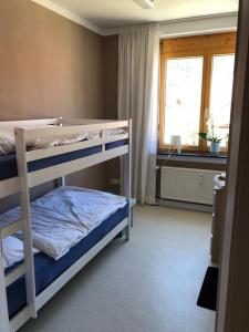 インメンシュタット・イム・アルゴイにあるGästehaus Moin Allgäuのベッドルーム1室(二段ベッド2台、窓付)が備わります。