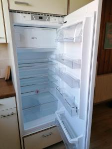 an empty refrigerator with its door open in a kitchen at Like on cloud nine - Apartment in Emmental 
