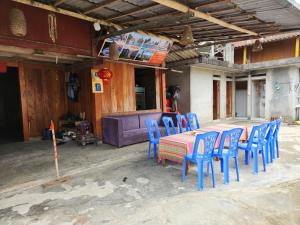 uma mesa com cadeiras azuis e um sofá numa casa em Yen homestay Ta Van em Sa Pả