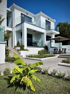 a large white house with some plants in front of it at Magic Kefalonia Villa in Spartia