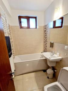 ein Badezimmer mit einer Badewanne, einem Waschbecken und einem WC in der Unterkunft Belle Apartments - Bratianu in Piteşti