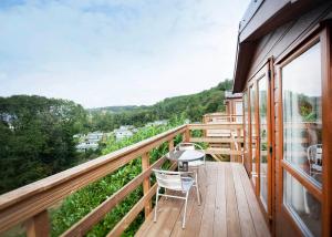 a balcony of a house with a table and chairs at Wigley Orchard in Clifton upon Teme