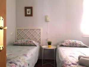 バレンシアにあるLoft in ehemaligem Fischer Hausのベッドルーム1室(ベッド2台、小さなテーブル付)
