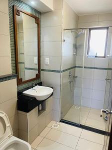 La salle de bains est pourvue d'un lavabo et d'une douche. dans l'établissement Lux Suites 2 Bedroom Sultan Palace Apartments, à Kikambala